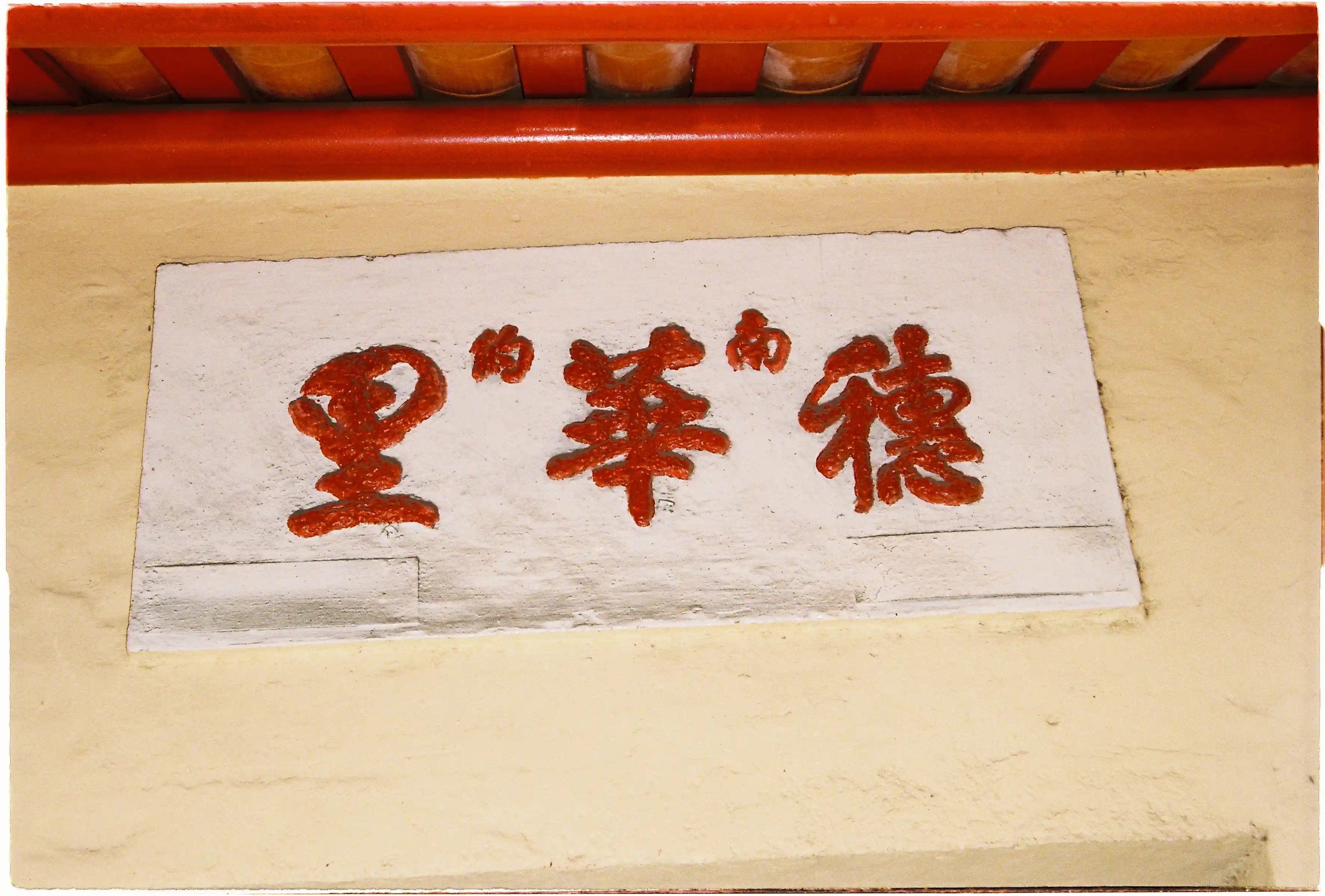 Biển hiệu ba chữ Hán màu đỏ đắp nổi trên nền tường vàng: Ảnh chụp flash ở tiêu cự tele sắc nét từ Canon Autoboy Jet