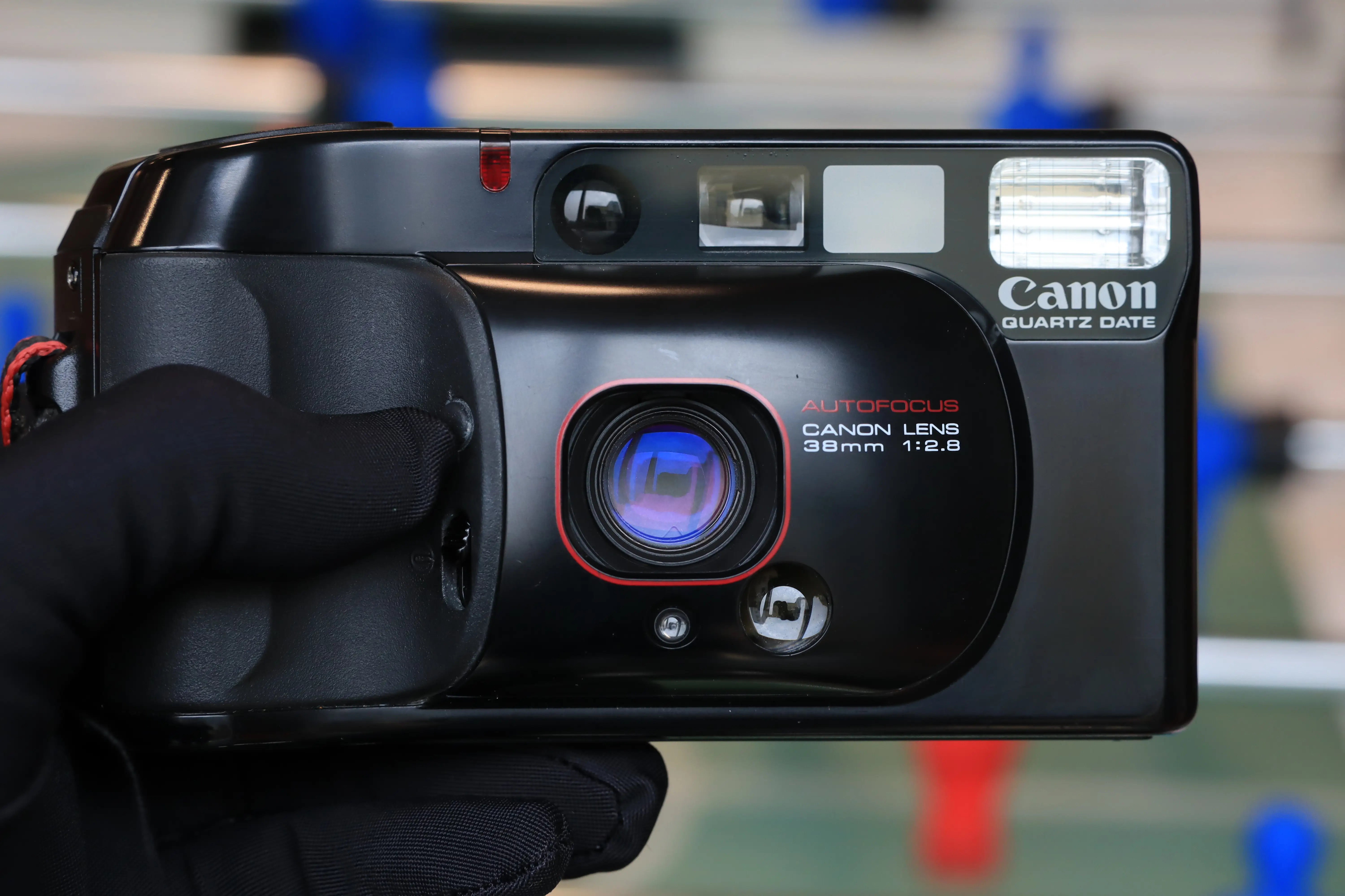 Lấy đèn soi vào kính trước và sau của máy phim point and shoot để kiểm tra chất lượng thấu kính