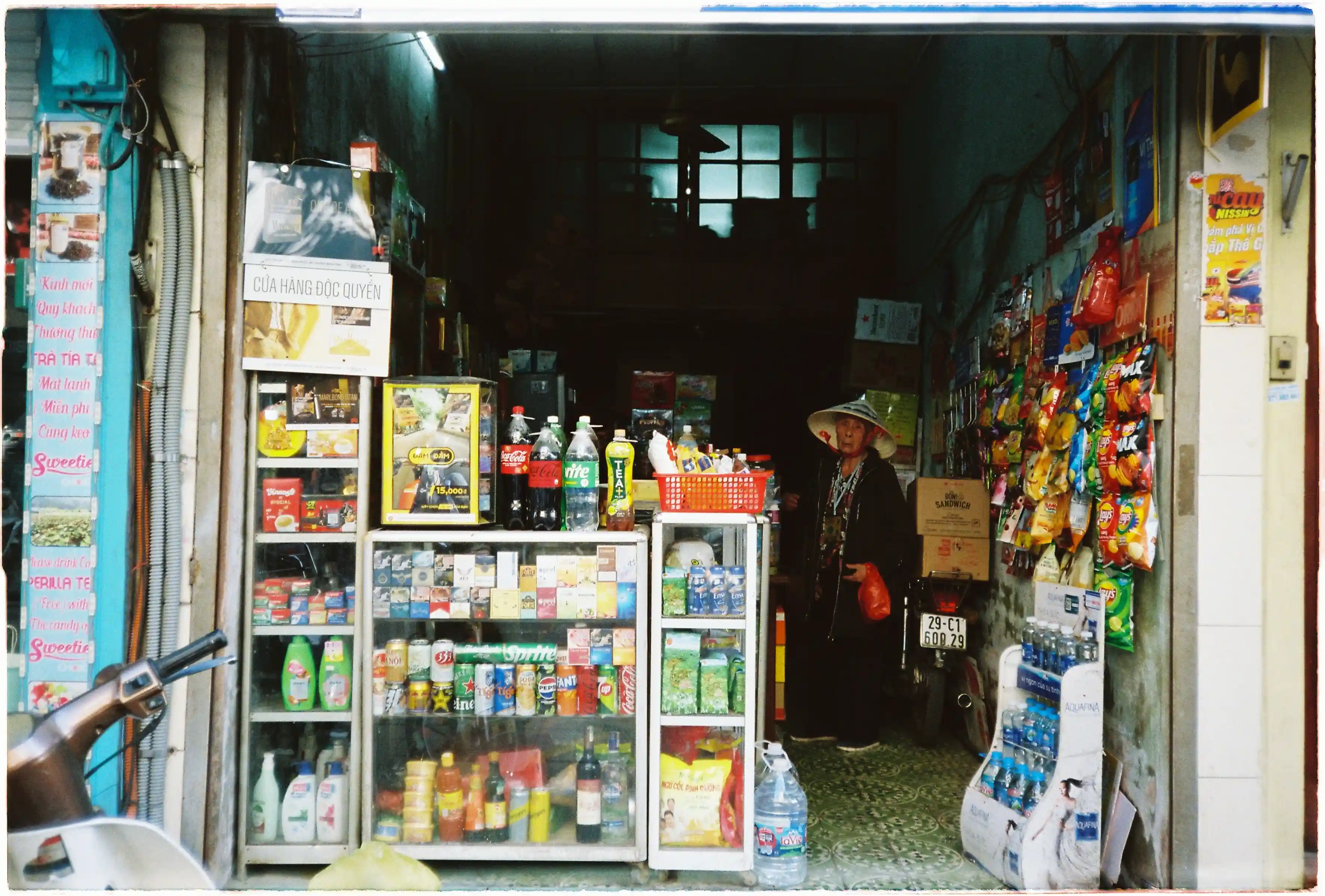 Cửa hàng tạp hóa truyền thống với người phụ nữ đội nón lá: Ảnh đời thường chụp tại 35mm bằng Canon Autoboy Tele 6