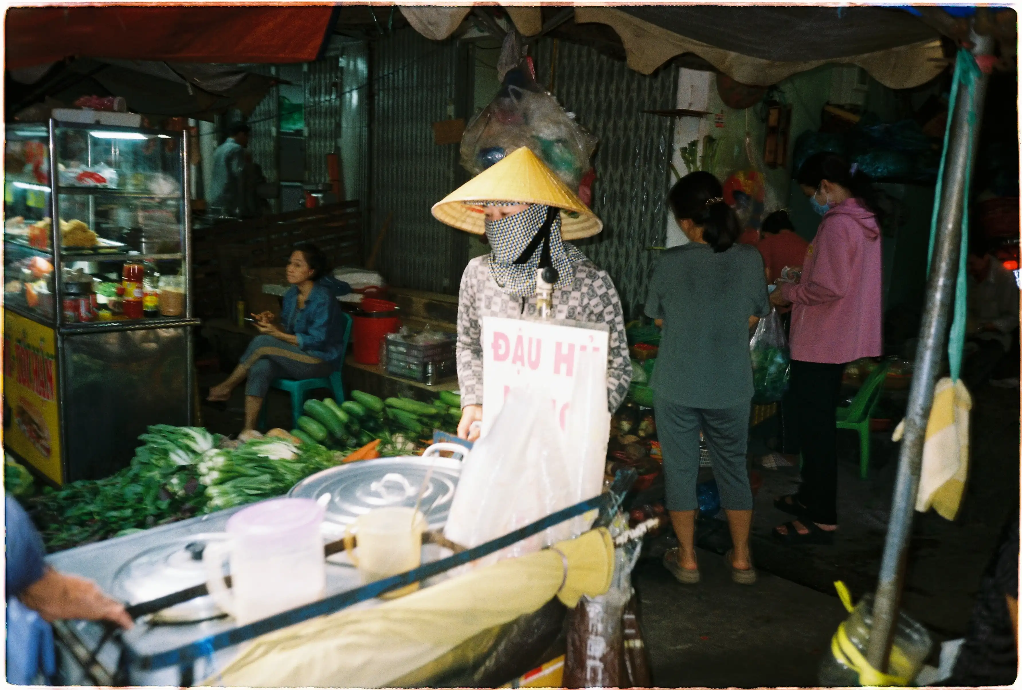 Ảnh chụp bên trong một khu chợ chật hẹp bằng Fuji Tiara Mini, ống kính góc rộng 28mm giúp bao quát toàn bộ lối đi đầy hàng hóa - Kodak Gold 200