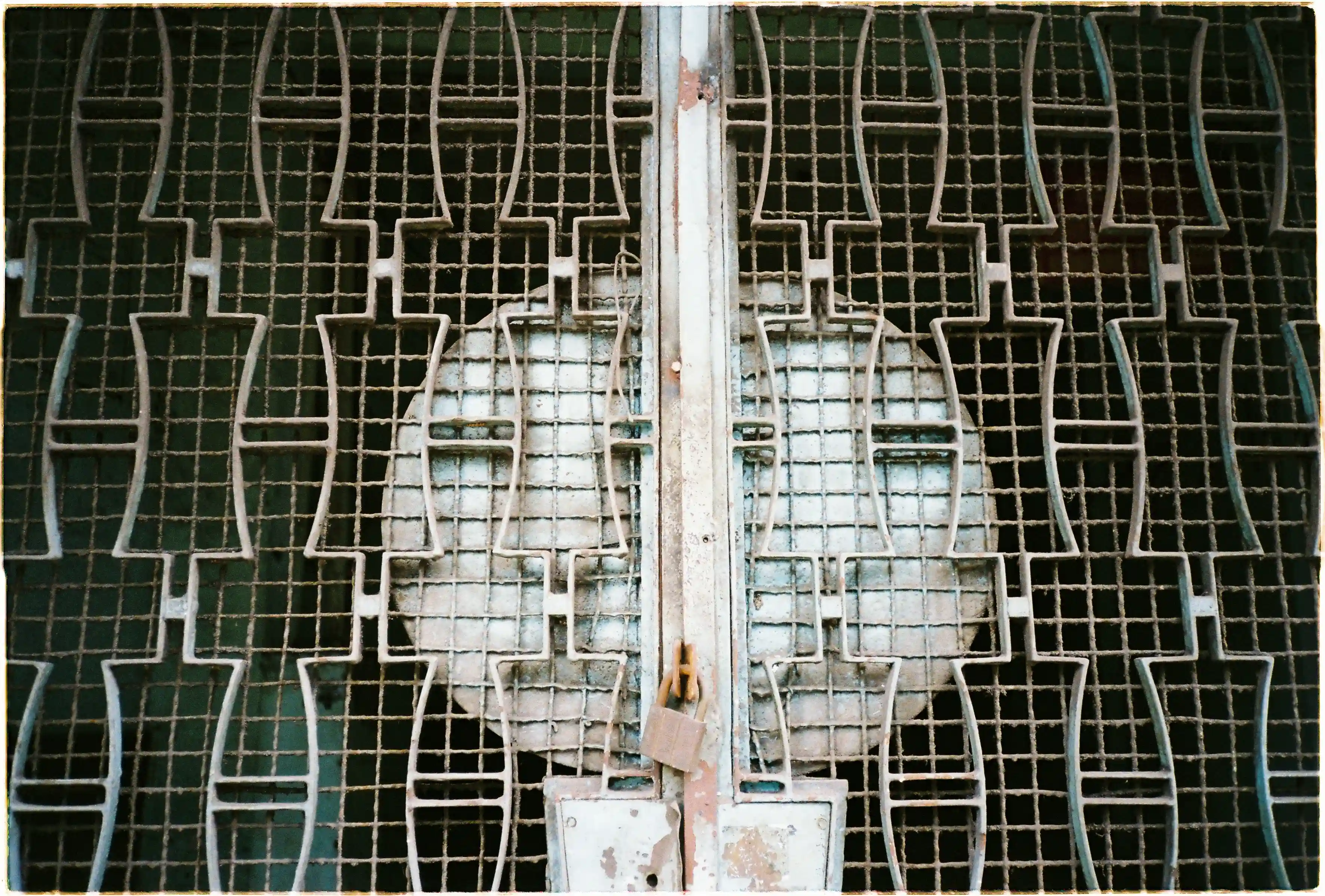 Ảnh chụp cận cảnh họa tiết cửa sắt cũ bằng máy Nikon L35AF, làm nổi bật độ sắc nét và chi tiết vân gỉ sét - Fuji 400.