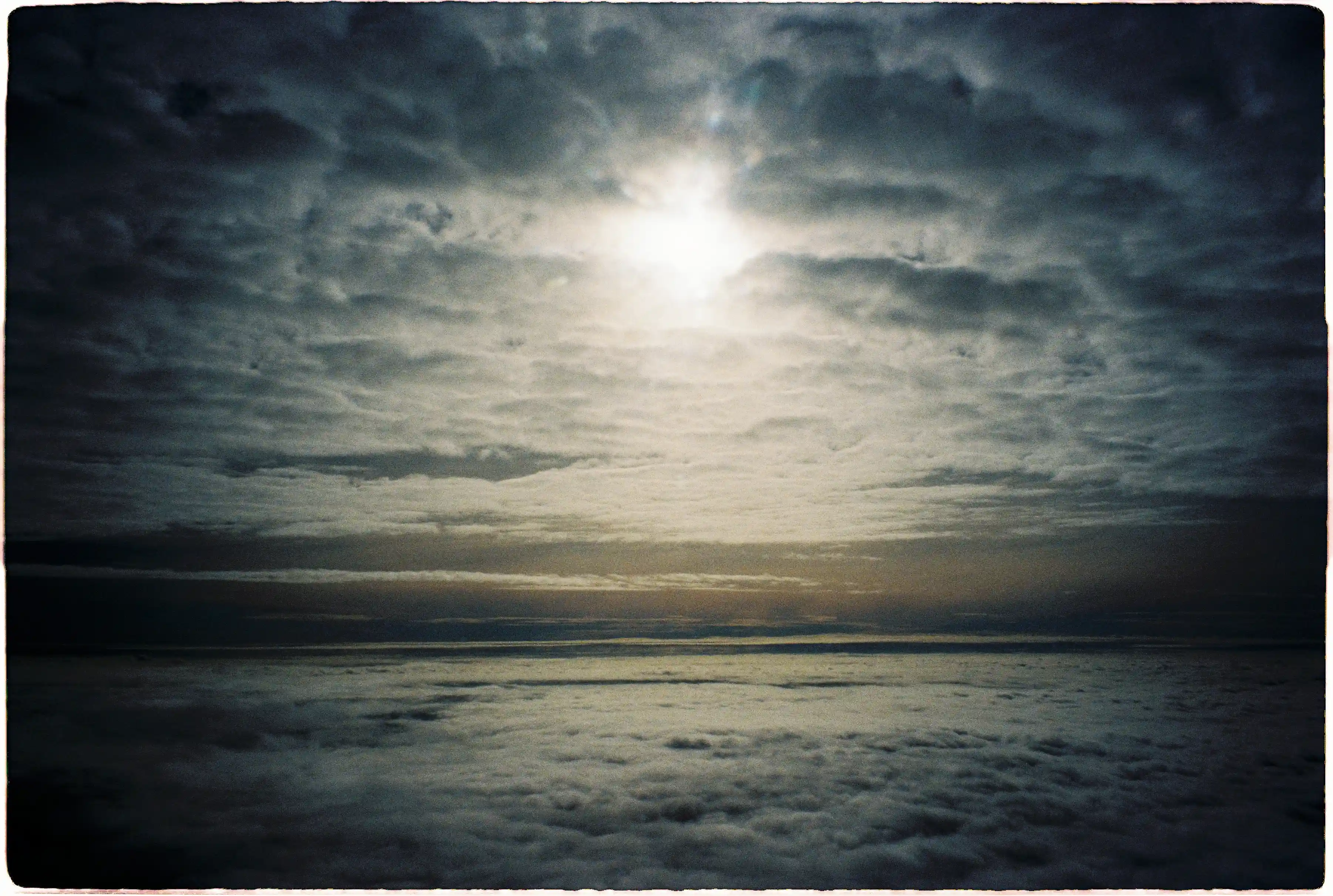 Ảnh chụp ngược sáng biển mây bằng Pentax Espio 120 SW II: Hiện tượng tối góc (vignetting) tự nhiên tạo khung viền bao quanh nguồn sáng mặt trời - Fuji 400