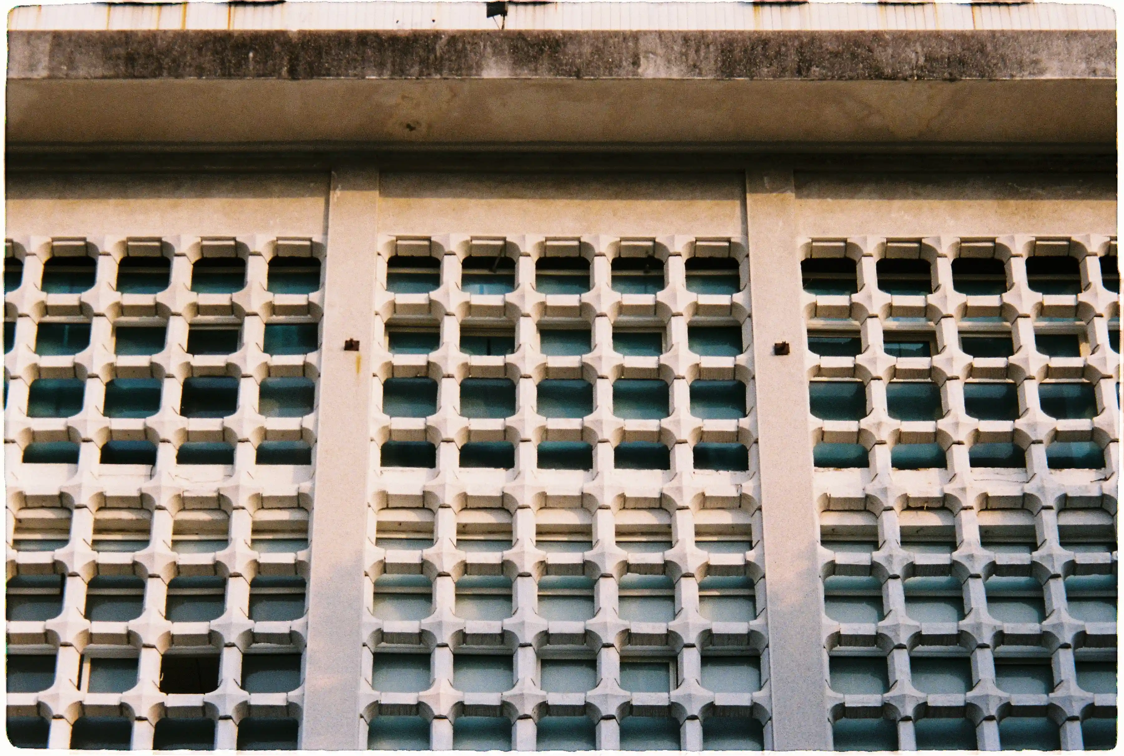 Cận cảnh họa tiết ô gió bê tông của tòa nhà dưới nắng chiều, ảnh chụp zoom xa sắc nét từ Pentax Espio 120 SW II - Fuji 400