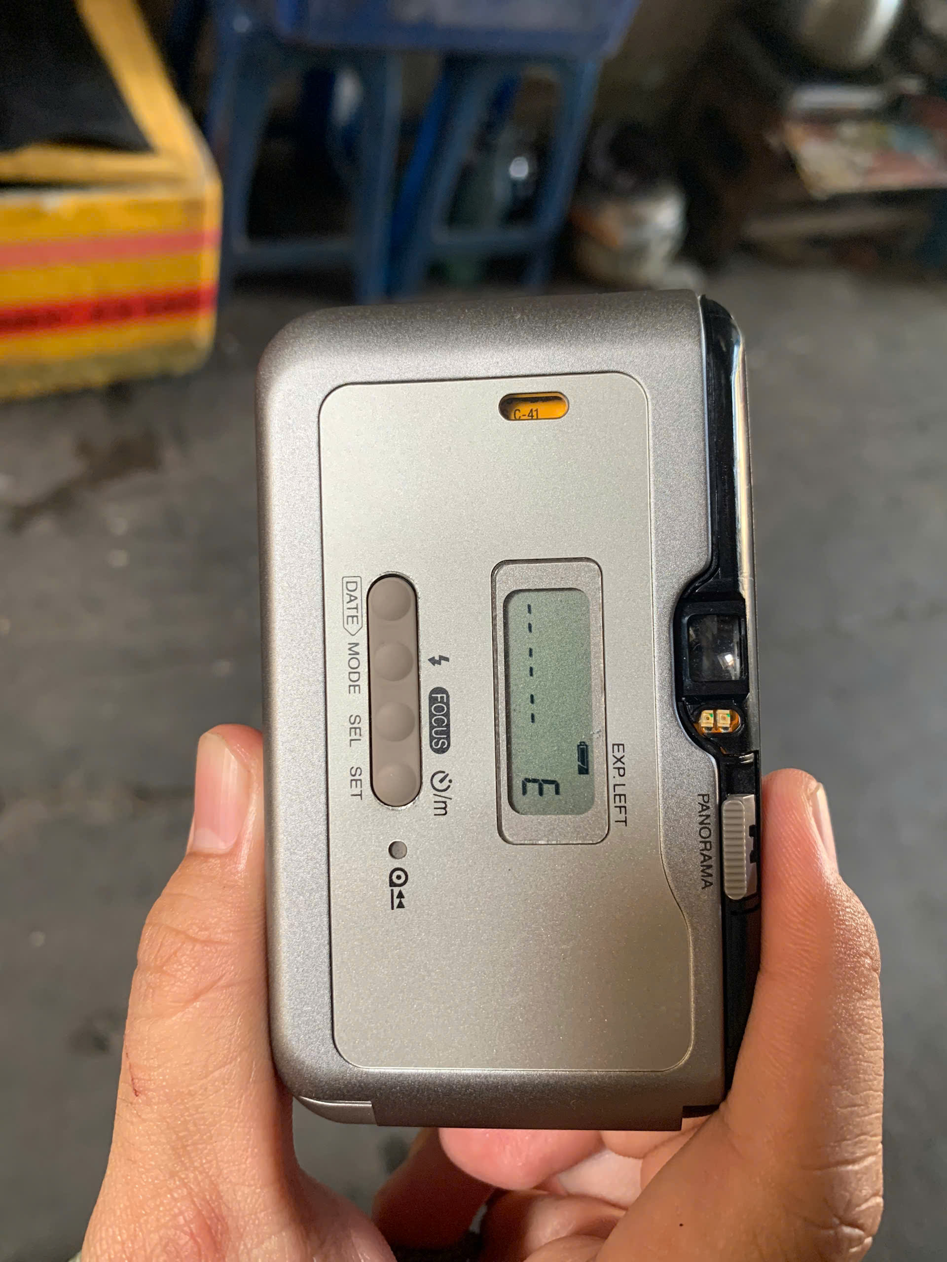 Kiểm tra ngoại hình mặt sau của máy phim point and shoot - ở đây nắp che viewfinder của máy này bị mất làm lộ ra phần màu đen