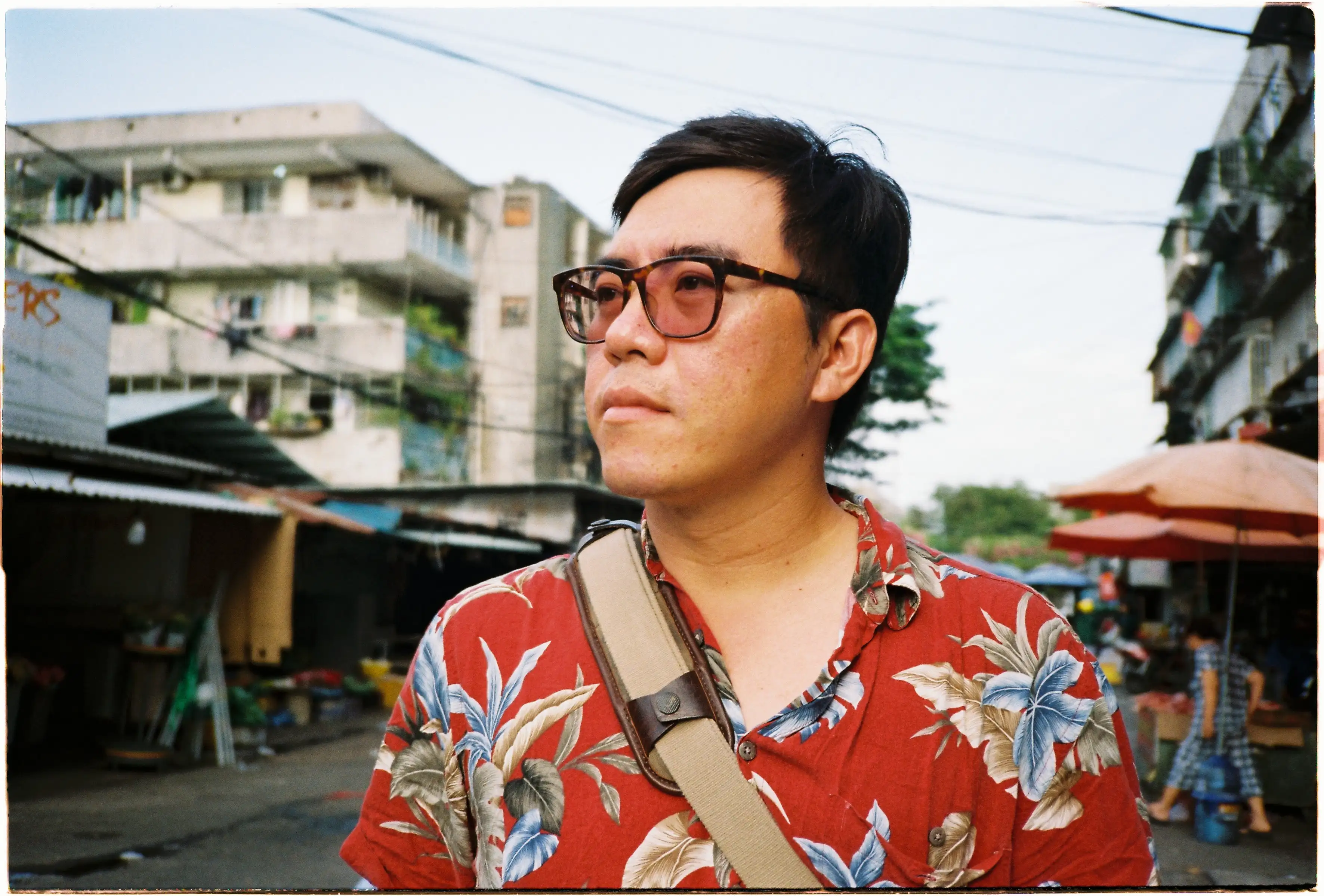 Ảnh chân dung nam giới trên phố: Ống kính f/2.8 của Canon Autoboy 3 làm mờ hậu cảnh, làm nổi bật chủ thể mặc áo hoa đỏ - Kodak Gold 200