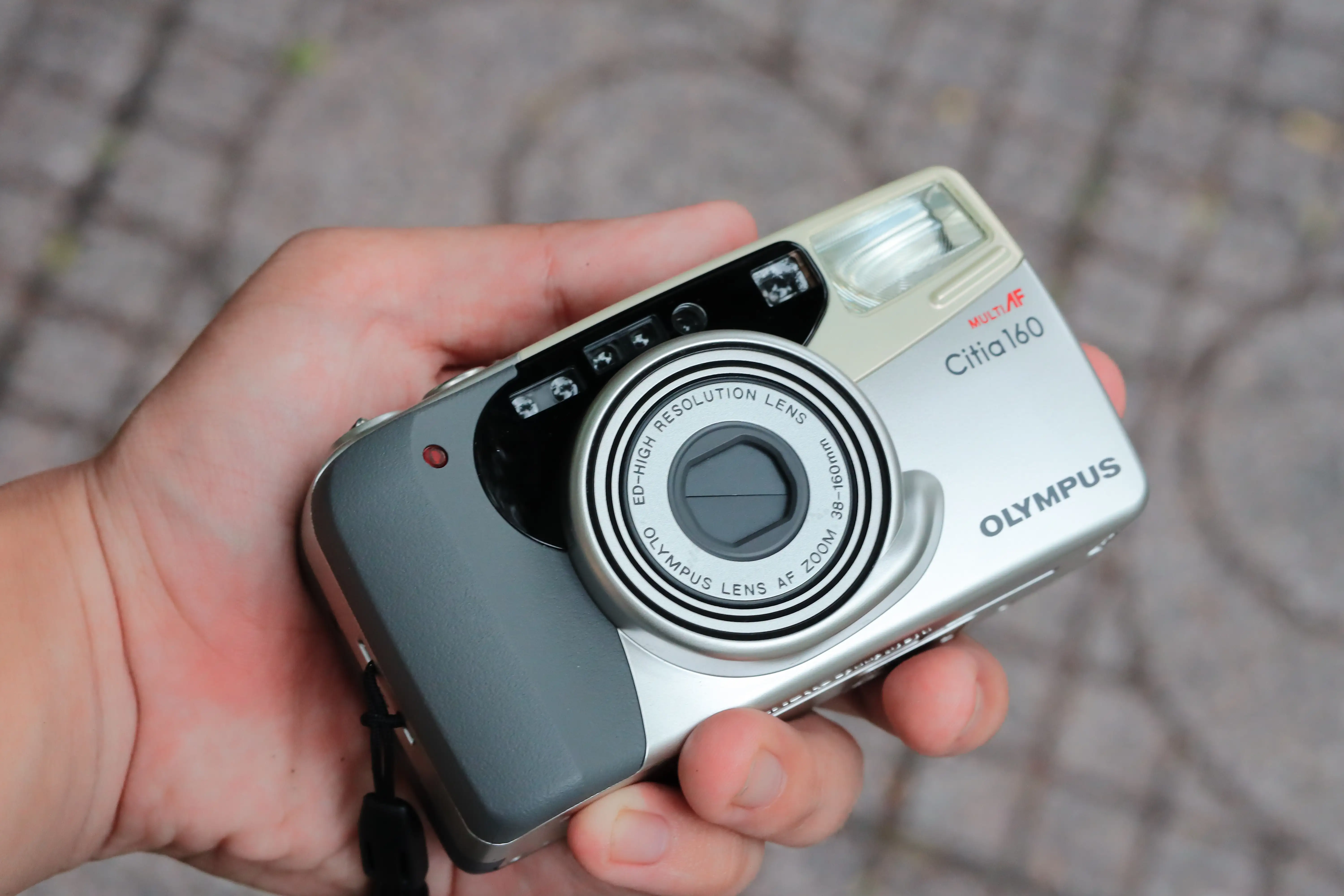Kích cỡ vừa lòng bàn tay của Olympus Citia 160, có báng cầm hỗ trợ.