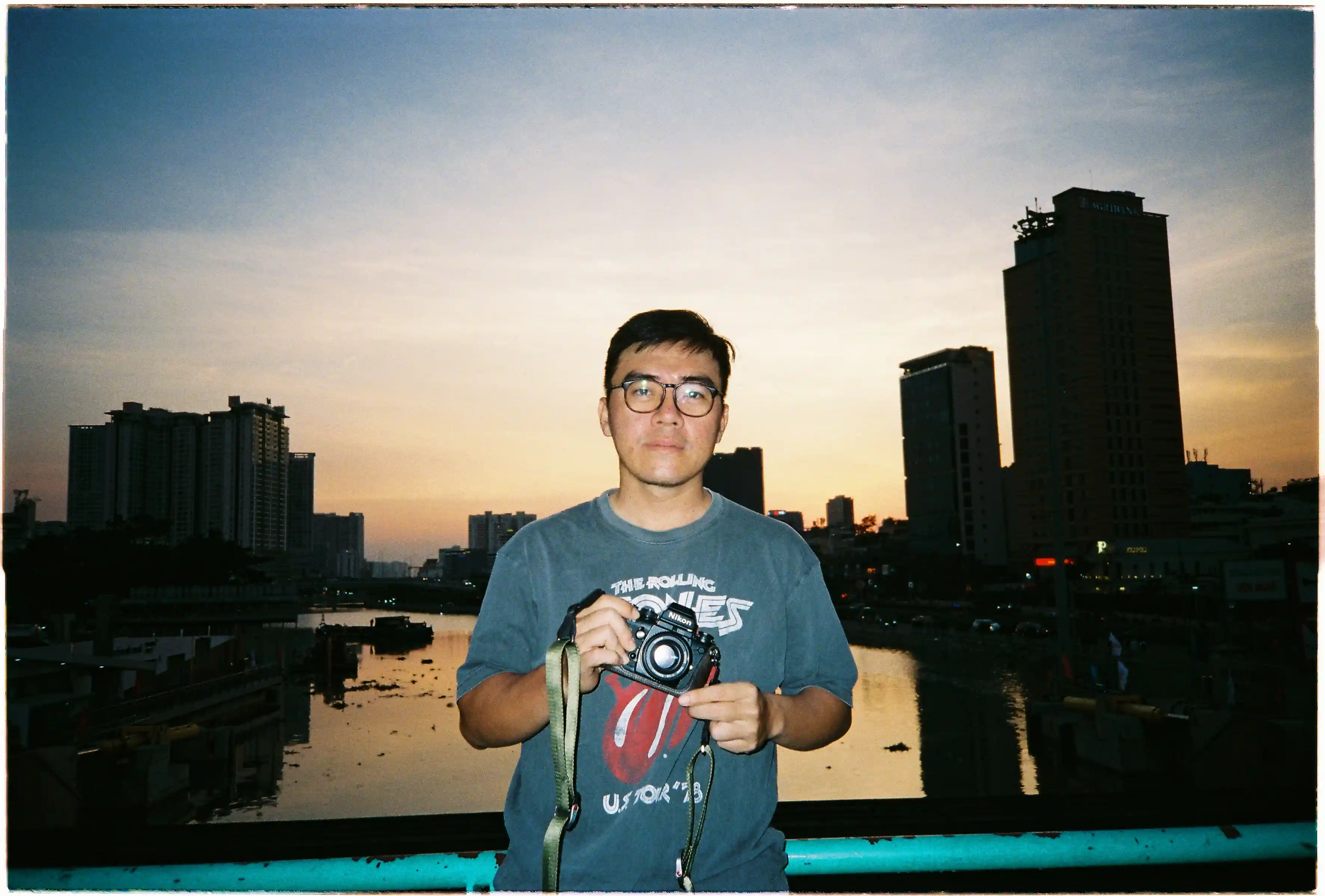 Chân dung trên cầu với hậu cảnh thành phố ven sông được chụp bởi Fuji Everyday OP: Ánh đèn flash cân bằng hoàn hảo với ánh sáng hoàng hôn màu cam tím - Fuji 400