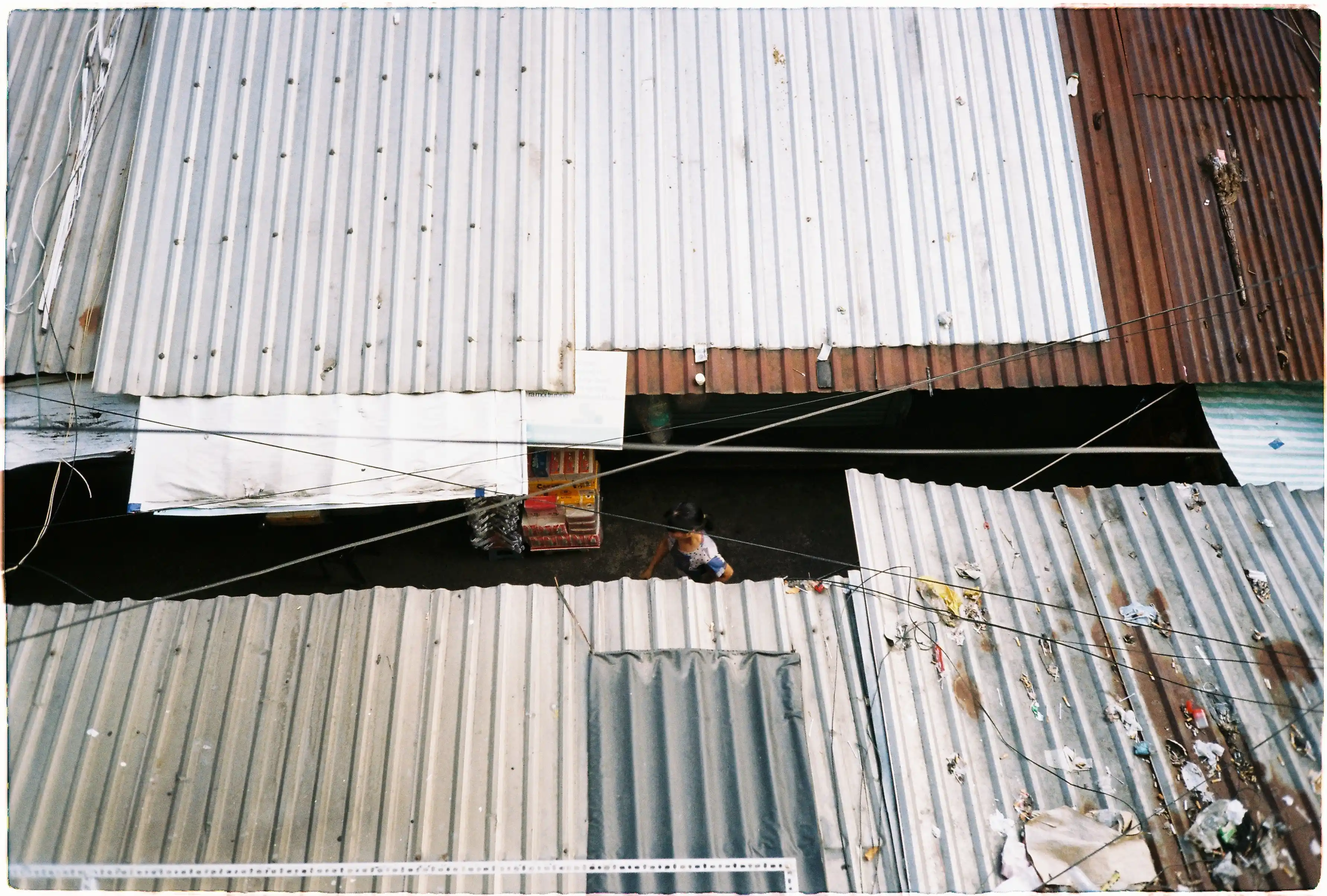 Ảnh đời thường chụp những mái nhà lợp tôn và người đi bộ trong hẻm nhỏ từ máy film Fuji Tiara - Kodak Gold 200